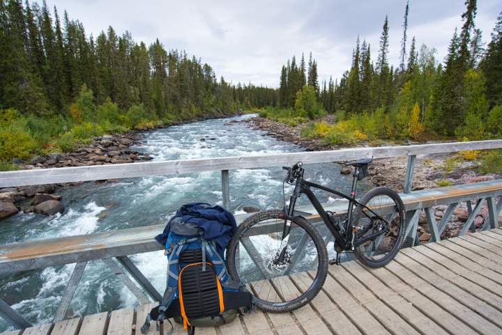 Ein Mountainbike und ein Rucksack auf einer Brücke.